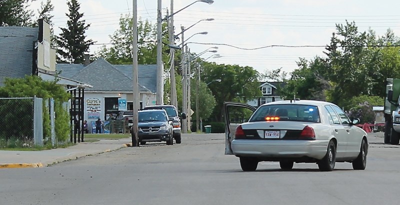 RCMP officers set up roadblocks in downtown Clyde after a man used a knife and bear spray to rob a local store on Friday afternoon. Two people were injured in the incident,