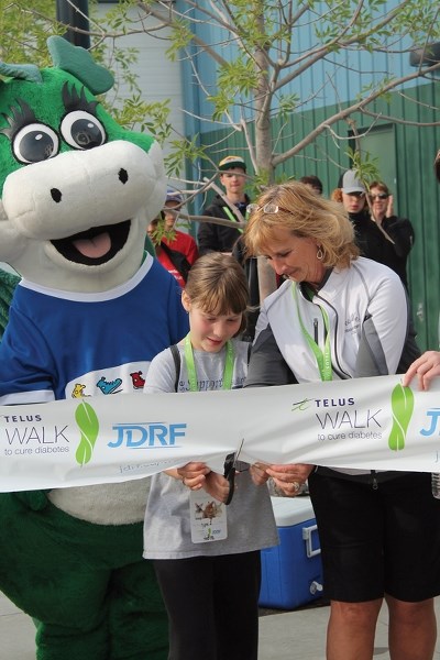 Local JDRF ambassador Heleena Neuman (centre), with some help from local event coordinator Val Hampshire and JD the JDRF Dragon, cut the ribbon to signal the start of the
