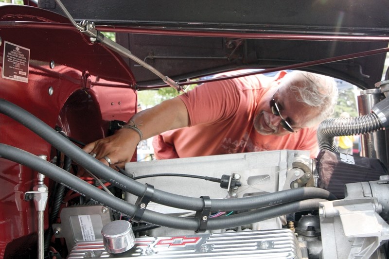 Kelvin Magega tinkers with the engine of his restored 1936 Chevrolet pickup truck at Sunday’s Westlock Wheels of Class Show N’ Shine held at Lindahl Park.