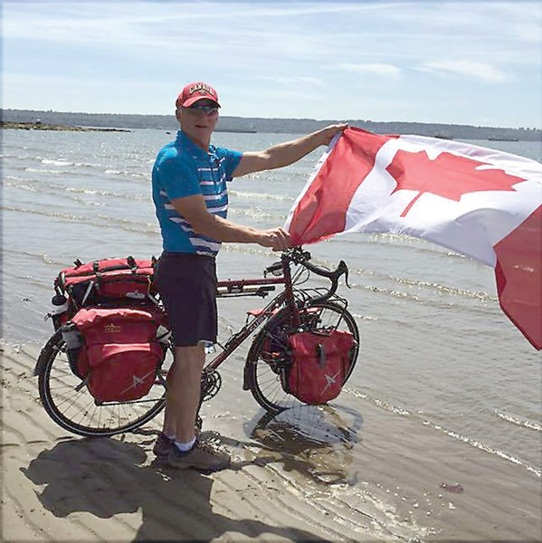Bryan Carnegie dips his bike into the Pacific Ocean June 17 before setting out on his charity bike trip.