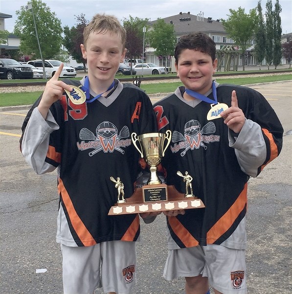 Westlock’s Seth Fairholm and Zach Basisty show off the gold medals and trophy they won as members of the North Edmonton Wizards following the club’s triumph at the Alberta