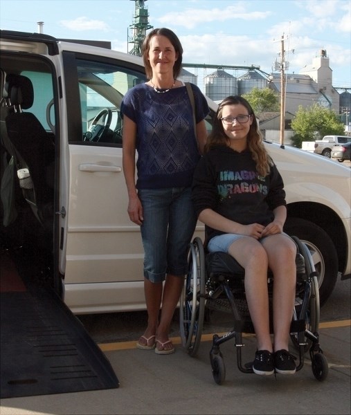 Melissa Nickerson (left) and her daughter Andrea Nickerson beside the wheelchair van they were able to purchase thanks to $27,000 they received in donations.