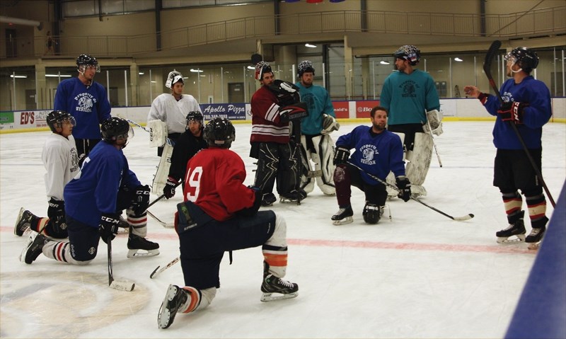 Players take a knee while getting instruction for the next drill at Westlock Senior