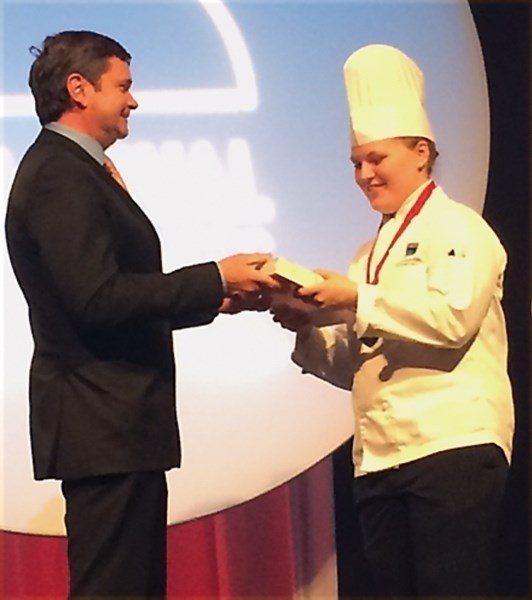 Katelyn Kuhar is presented with an award from the Stan Ballard Apprenticeship Fund by provincial minister for agriculture and forestry Oneil Carlier. The presentation was