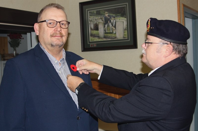 Town of Westlock mayor Ralph Leriger (left) gets the ceremonial first poppy from poppy chairman Jim MacCarahan at the Westlock Legion on Friday, Oct. 30.