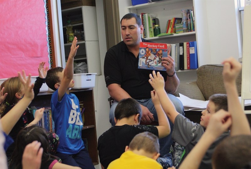 Westlock RCMP Const. and hockey coach Dave Wilejto reads to Jim Schaffer’s Grade 3 class at Busby School on Nov. 26 during the school’s first-ever read-in week.