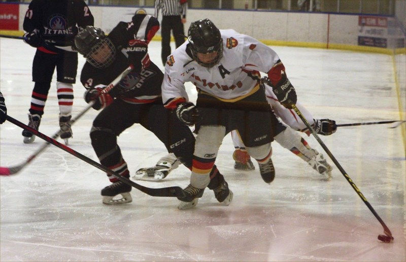 The Westlock Peewee Warriors skated away with a 6-5 win over the Thorhild Titans on Saturday, Dec. 12. Warrior Blain Rinas hangs on to the puck after taking a hit.