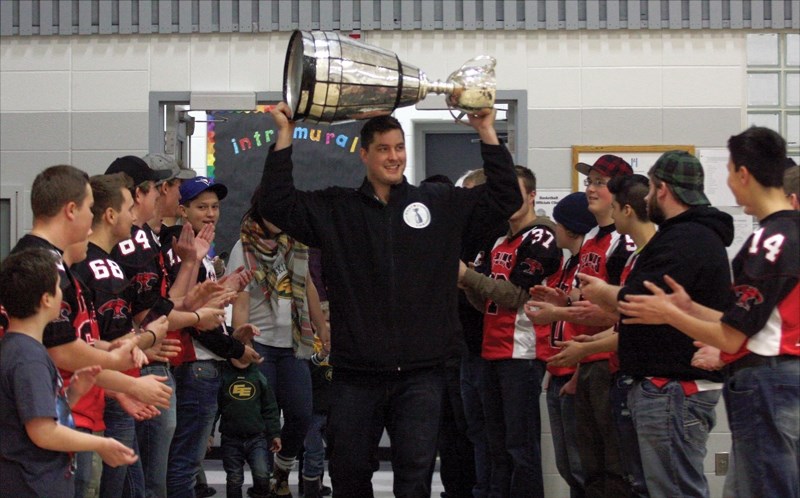 Former R.F. Staples student and 2015 Grey Cup champion Simeon Rottier is greeted by the Westlock Thunderbirds football team as he enters the school’s gym with the cup on Dec. 