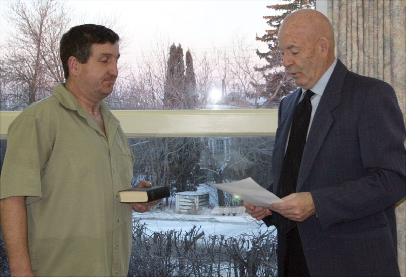 New Westlock County Div. 3 Coun. Raymond Marquette takes the Oath of Office from reeve Bud Massey on Tuesday, Jan. 12. Marquette was the only person to put his name forward
