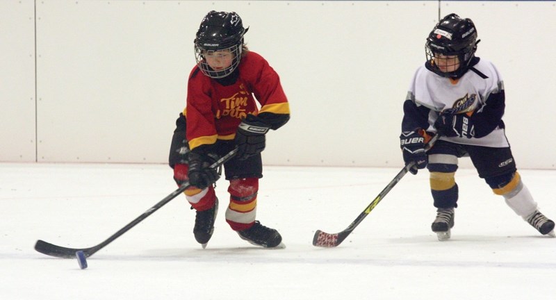 Westlock Initiation 3 Warrior Dayce Madson (left) corrals the puck during a matchup against the CNN Spurs during Westlock Minor Hockey Association’s initiation tournament on