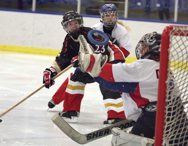 Edmonton Black Gold Rush’s Jordie Richardson (23) watches her shot sail over the glove of Edmonton Wam’s Jessi Daniels during their National Ringette League matchup at the