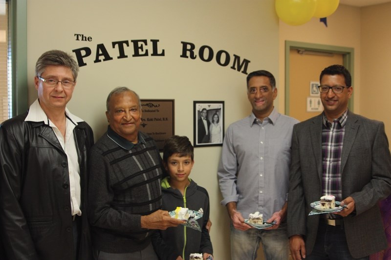 L-R: Dr. Jan Lategan and Dr. Shashi Patel, alongside grandson Jadan Patel and sons Suru and Anul Patel enjoy a slice of cake during the dedication of the Patel Room at the