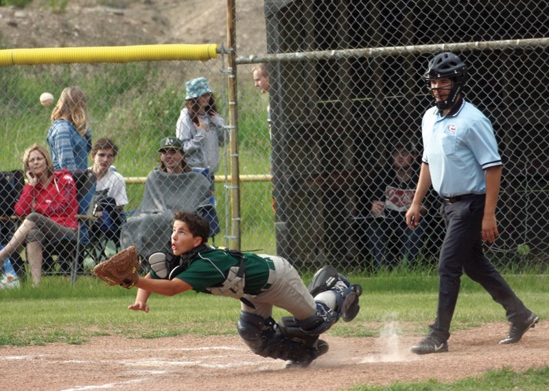 Bantam Wild catcher Deano Allcock dives for a pop-up during the club’s 9-8 June 22 home loss to Legal. The defeat is club’s only regular-season loss as they compiled an 11-1