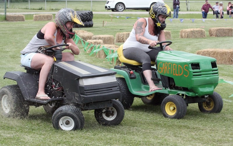 Andrea Gibson (left) tries to overtake sister Stephanie Jean during lawnmower races at Jarvie Days on Saturday, July 23.