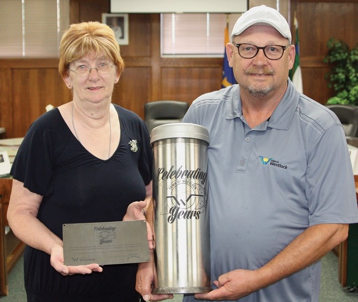 Westlock 100th Anniversary Committee Member Rose Olson and mayor Ralph Leriger hold the town’s commemorative time capsule and plaque in council chambers July 29. Once filled, 