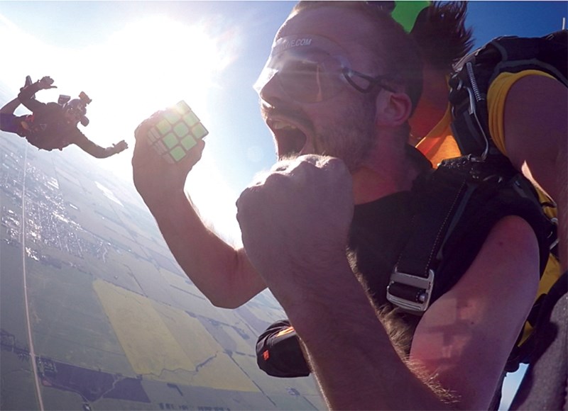 Stephen Robinson celebrates after solving a Rubik’s Cube during freefall, part of his How to Learn Anything web series, sponsored by Telus’ Storyhive. The stunt earned him