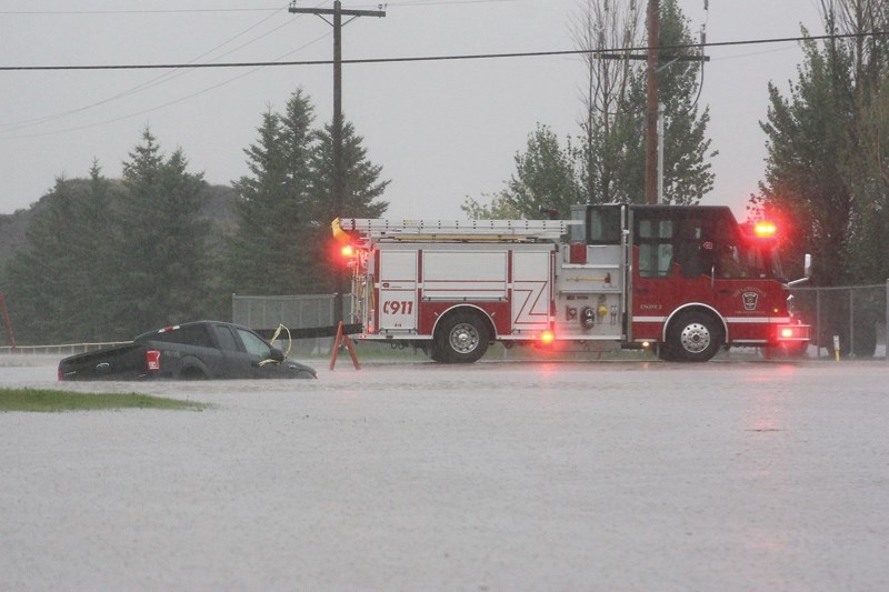 Emergency crews respond to a submerged truck outside of the Westlock bottle depot Monday night.