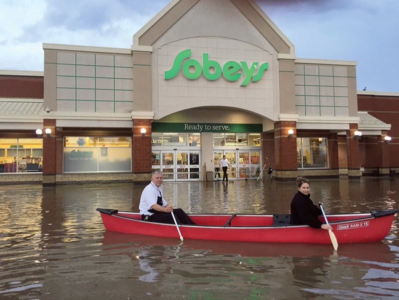 Who needs to go to the lake? This photo taken by Bryanna Findlay shows Sobeys’ owners Tom and Susan Vesely paddling a canoe across the store’s parking lot on Aug. 22. In the