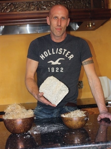 Dion Lefebvre holds up a brick of hempcrete, a concrete-like cement made from the hemp plant mixed with a lime-based binder, the material used to build his new &#8220;tiny