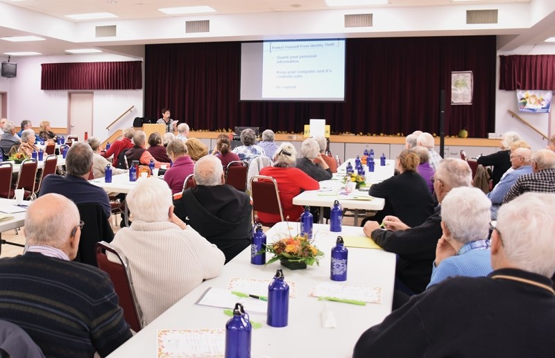 Maureen Hollands of Wise Owl, an anti-fraud education group for seniors, speaks to the crowd about signs of fraud and how to protect themselves from scams at the FCSS