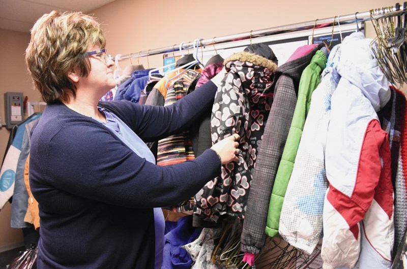 Westlock and District FCSS program co-ordinator Carol Kassian hangs up a donated winter coat outside the FCSS office for the Coats for Kids and Families campaign.