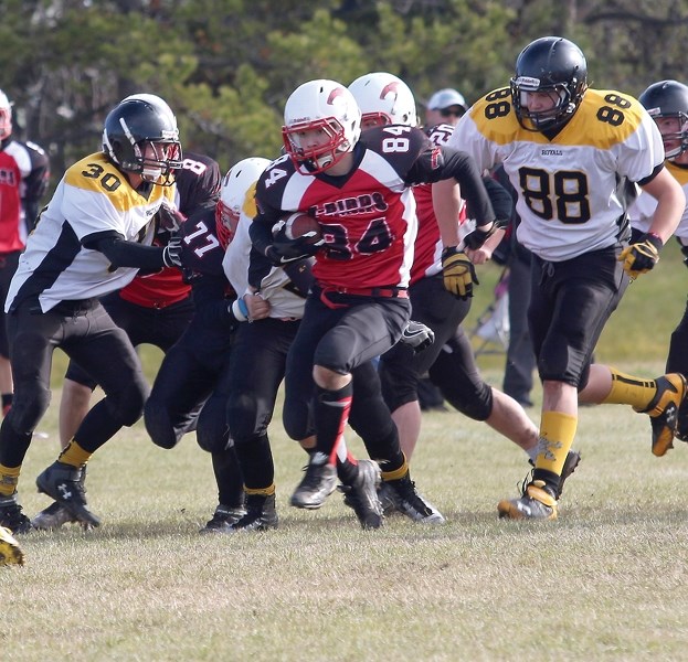 Thunderbird Mathew LeBeau blasts past Cold Lake Royals Anthony Francis and Thomas Kell during the Wheatland Football League consolation semifinal held at Westlock Elementary