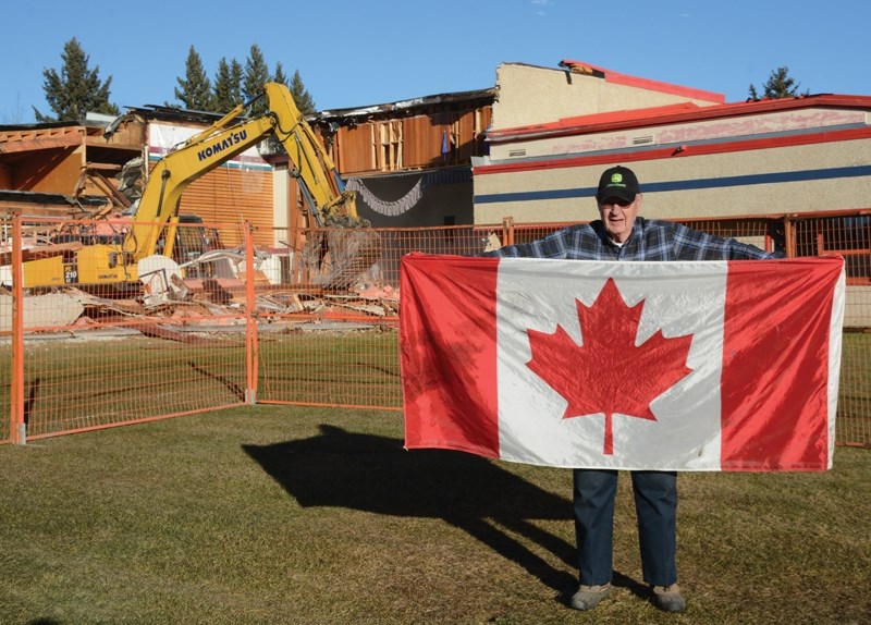 Werner Frose, for whom the Fawcett school was named in 1990, holds up the Maple Leaf that was hung in the school’s gymnasium as demolition crews bring down the old school
