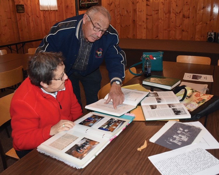 Longtime St. Patrick Catholic Church parishioners Maureen Parrent and Howard Ringstad browse photos of the Catholic Women’s League, which is celebrating its 60th anniversary