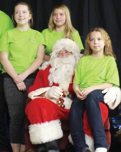 Three of the Westlock Wildcards 4-H Club, Katie McLaughlin, Emily Bickford and Alyssa Melanson, take a moment to pose with Santa Claus at the Busby Christmas Market Dec. 4.