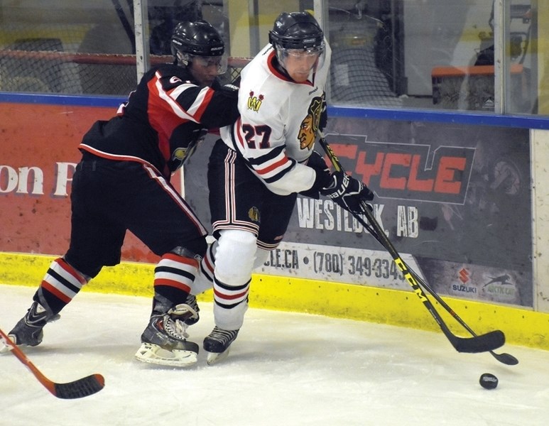 Senior Warriors Ryan Nelles battles for a loose puck during a 13-2 home win over the Slave Lake Winterhawks Dec. 10. On Sunday the club travelled to Eckville where they