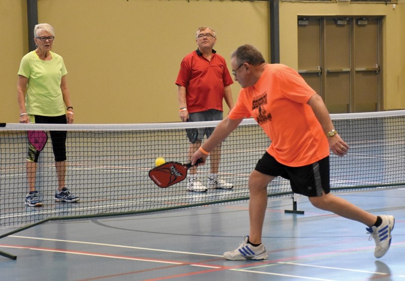 George Oko backhands the ball over the net to Caren Gawryluk (left) and David Lent. Pickleball players matched off for an afternoon round robin game at the Rotary Spirit