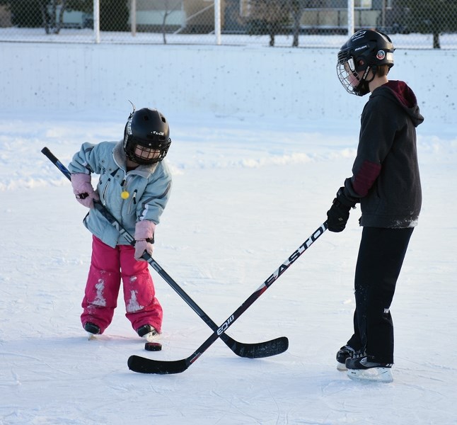Mild temperatures Dec. 27 brought out five-year-old Abbie Bennett (l) and her brother Hayden, 9, from the great indoors to enjoy some ice time at the Eastglen outdoor rink.