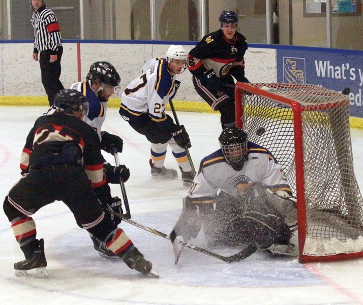 Warriors defenceman Kolbe Waldner tries to chip the puck over Bonnyville Pontiacs goaltender Marcus Johnson as teammate Philip Ferenac looks on. The Warriors ended their
