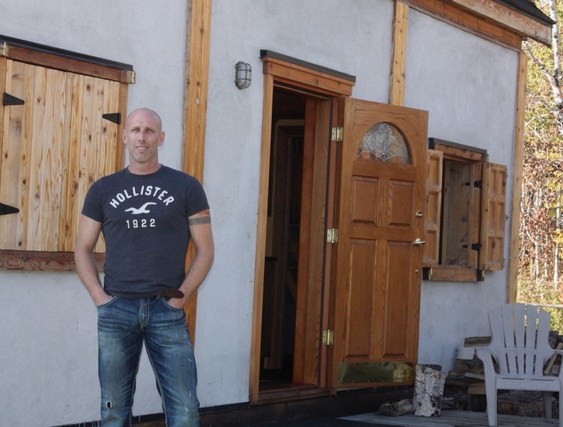 Dion Lefebvre poses in front of his hempcrete home which he completed last summer. Hempcrete is a concrete-like block made of hemp and lime mix.