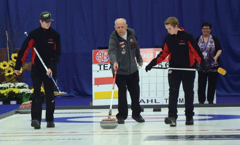 Ray Wildfong, ringed by sweepers Lamont Montgomery and Matthew Burchett, throws the first ceremonial rock of the 2017 Alberta Boston Pizza Cup during the event’s opening