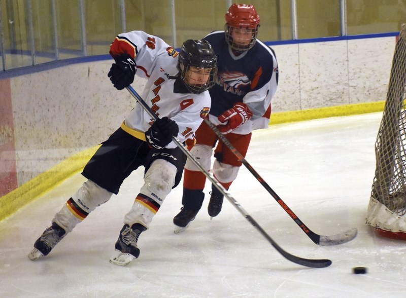 Westlock Bantam Warrior Keenan Fortier scoops a puck past Sturgeon’s Cole Jensen in the second period. The Warriors defeated Sturgeon 6-3 Feb. 18 at the Rotary Spirit Centre.