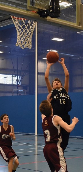 St. Mary Shark Jake Raegan takes a short jump shot over a Legal forward. The Sharks netted a 55-28 win against Legal in a Friday match up.