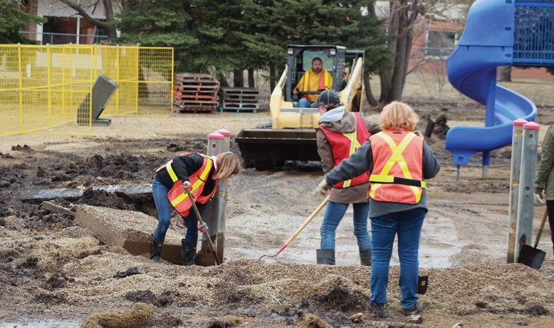 Kristi Woodcock, Chelsie Mueller and Cindy Ferris of the St. Mary Fundraising Committee dig up the foundations of the old playground April 7. The school’s new $350,000