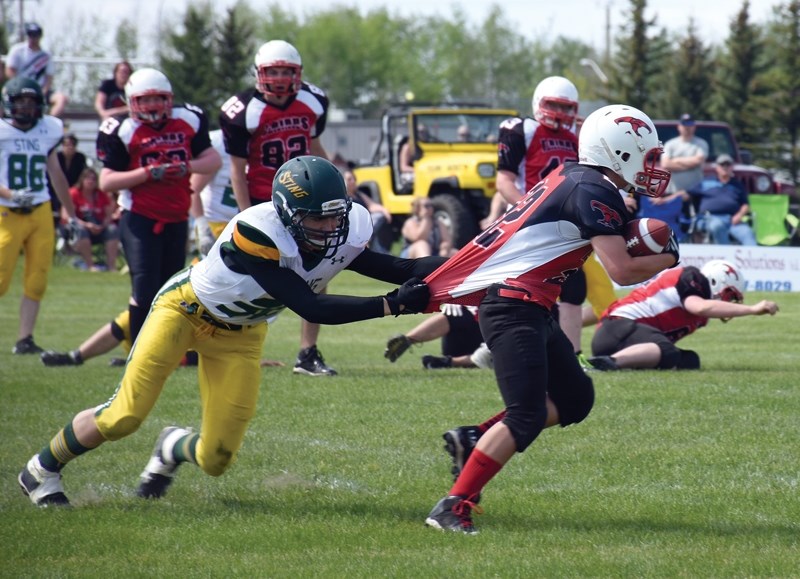 A Fort Saskatchewan Stinger grabs T-Bird Deano Allcock during the club’s annual football jamboree May 27 at Westlock Elementary School.