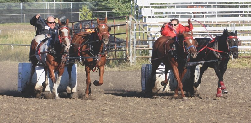 Dave Uden and Dakota Schalin race down to the finish line in the seventh heat of the chariots race Aug. 19 at the 103rd annual Westlock and Dis-trict Agricultural Fair. Uden