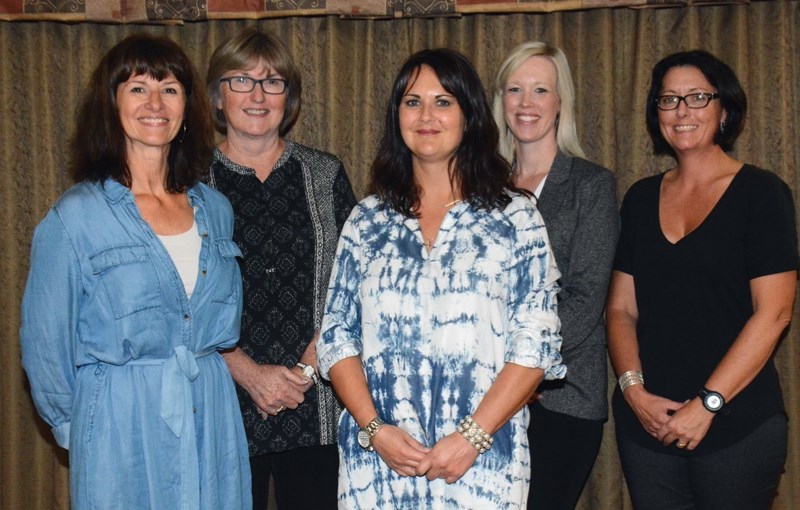 Recreation therapist Lori Kary (centre) receives $11,600 at the Sept. 21 100 Women Who Care event on behalf of recipient Homeland Housing, flanked by organizers Deneen