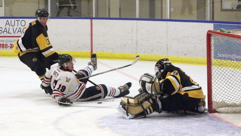 Westlock Warriors coach and team captain Mike Ivey is pulled down during a rush to the Devon Barons’ net Oct. 7. The Warriors dropped the exhibition game 4-3 and now look