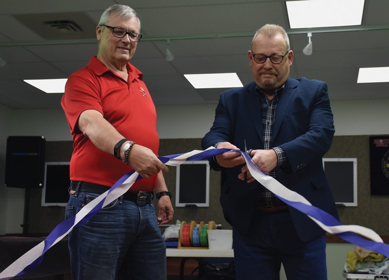Westlock Legion president Dave Hall helps Town of Westlock mayor Ralph Leriger cut the ribbon at the Legion’s basement lounge grand re-opening Oct. 14