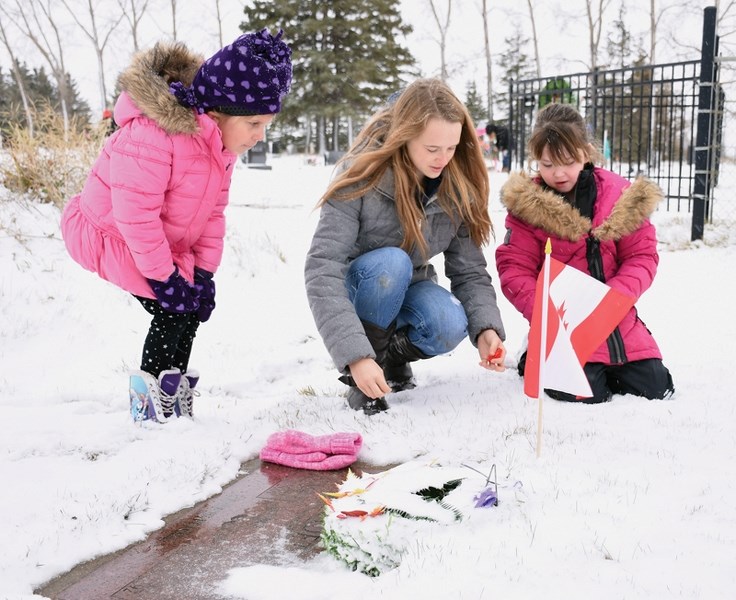 St. Mary School students from Grades 1 and 12 joined together to remember the 32 soldiers who rest at St. Mary Cemetery and place flags and poppies on their graves as part of 