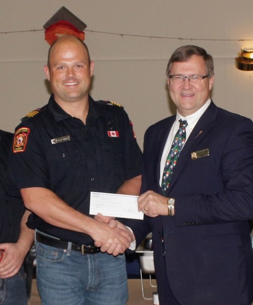 Barrhead-Morinville-Westlock MLA Glenn van Dijken presents Busby Volunteer Fire Department Deputy Chief Dean Dumbeck with a $30,000 matching grant. The money will go toward