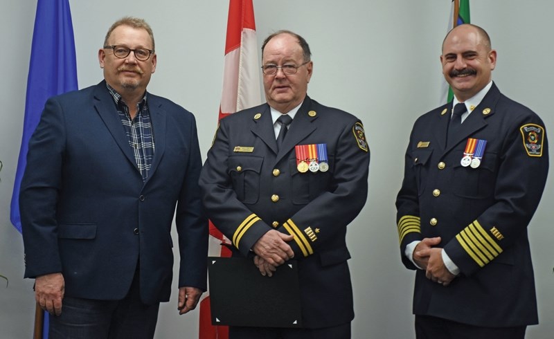 Westlock Volunteer Fire Department Captain Bill Smith (centre) was recently recognized with the Alberta Emergency Services Medal for his 22 years of service. Mayor Ralph