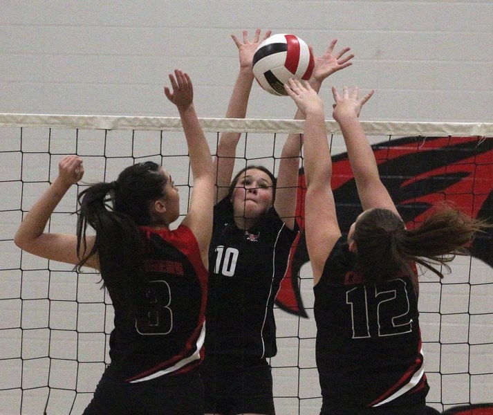 R.F. Staples T-Bird Karis Huppertz leaps to stop two Hilltop High School Charges during North Central Zone 3 championships hosted in Westlock Nov. 17-18. The T-Birds fought