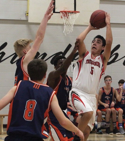 T-Bird Dalton Greanya leaps past a swarm of defenders in a league game against Morinville Composite High School at R.F. Staples School Dec. 6. The boys lost their tilt, while 