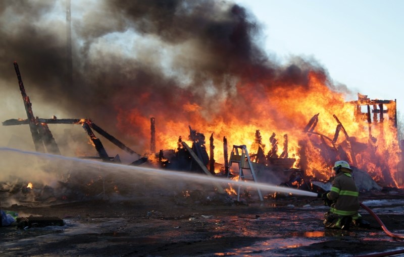 Busby Volunteer Department Chief Jared Stitsen battles a massive fire that destroyed a barn and multiple vehicles south of Clyde Dec. 15. Four fire departments sent 16