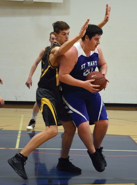 A Covenant Canadian Reformed School Stingerz defender tries to block Wyatt Granger during the Sharks’s 72-66 Dec. 14 home win.